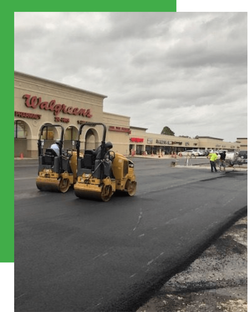 Fresh asphalt overlay at a Walgreens retail parking lot with rollers compacting